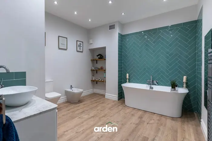 Family bathroom with a freestanding bath and herringbone tile