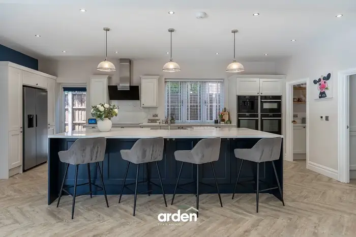 Shaker kitchen with a quartz island and bar stools